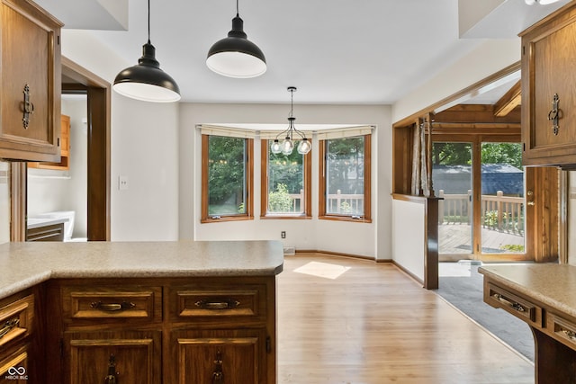 8439 Goldfinch Cir, Indianapolis, IN 46256 - kitchen featuring light wood-style floors, pendant lighting, light countertops, and a peninsula