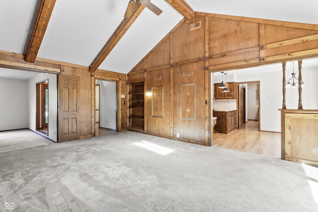 8439 Goldfinch Cir, Indianapolis, IN 46256 - unfurnished living room with wood walls, high vaulted ceiling, built in features, light carpet, and beam ceiling