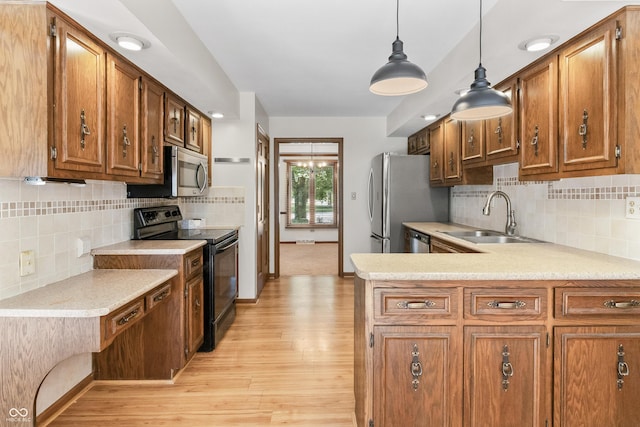 8439 Goldfinch Cir, Indianapolis, IN 46256 - kitchen with appliances with stainless steel finishes, light countertops, light wood-style flooring, brown cabinetry, and backsplash