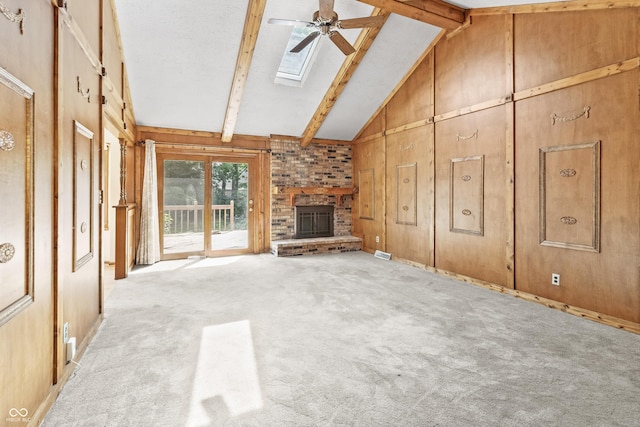8439 Goldfinch Cir, Indianapolis, IN 46256 - unfurnished living room featuring a skylight, beamed ceiling, a fireplace, ceiling fan, and light carpet