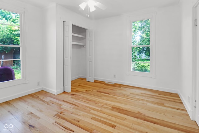 2400 Walnut St, Anderson, IN 46016 - unfurnished bedroom featuring light wood finished floors, multiple windows, and ceiling fan