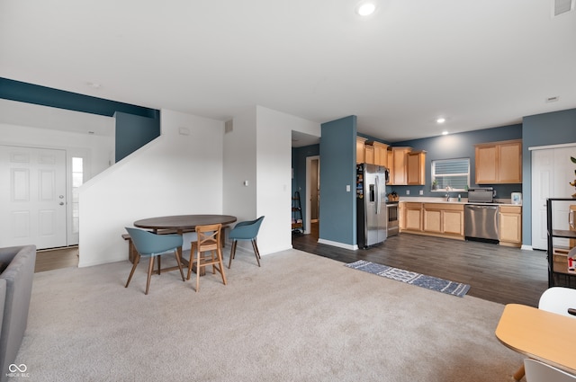 77 Winding Brook Way, Pendleton, IN 46064 - kitchen with stainless steel appliances, light brown cabinets, open floor plan, light countertops, and dark colored carpet