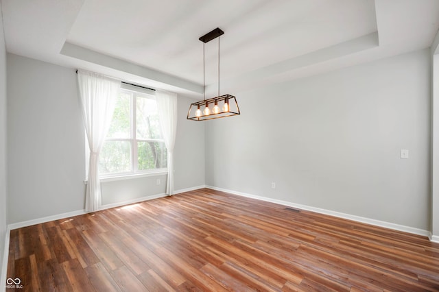 8578 Nolan Dr, Fishers, IN 46038 - spare room featuring a tray ceiling, wood finished floors, and a chandelier