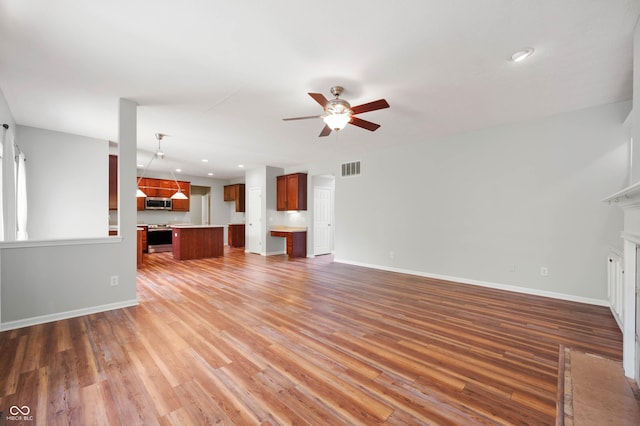 8578 Nolan Dr, Fishers, IN 46038 - unfurnished living room featuring ceiling fan, light wood finished floors, a fireplace with flush hearth, and recessed lighting