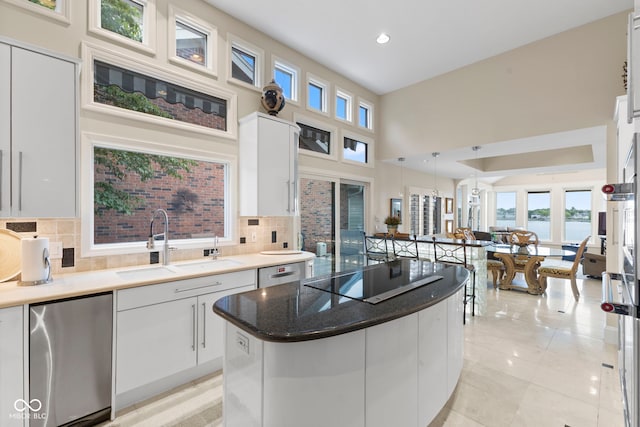 8164 Dean Rd, Indianapolis, IN 46240 - kitchen with black electric cooktop, a water view, backsplash, white cabinetry, and a high ceiling
