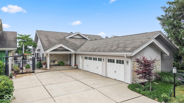 8164 Dean Rd, Indianapolis, IN 46240 - view of front of house with a garage, stone siding, roof with shingles, and driveway