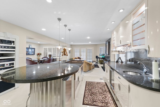 8164 Dean Rd, Indianapolis, IN 46240 - kitchen with recessed lighting, a breakfast bar area, white cabinets, dark stone countertops, and dishwasher