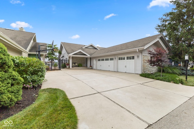 8164 Dean Rd, Indianapolis, IN 46240 - view of side of property with an attached garage, stone siding, driveway, and roof with shingles