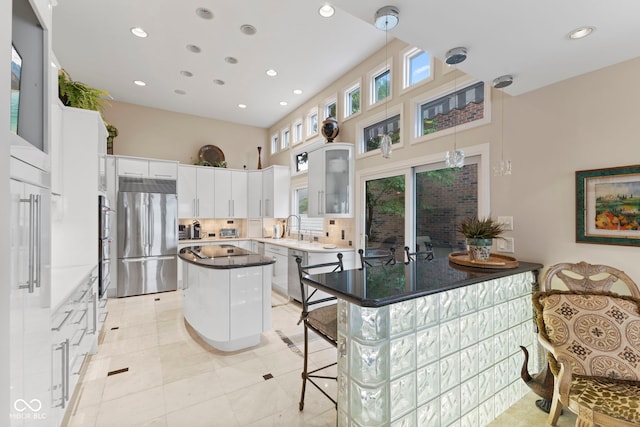 8164 Dean Rd, Indianapolis, IN 46240 - kitchen with appliances with stainless steel finishes, a kitchen island, recessed lighting, glass insert cabinets, and decorative light fixtures