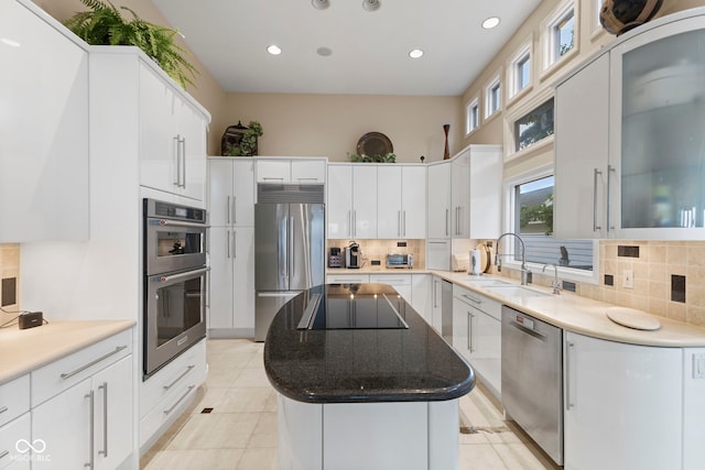 8164 Dean Rd, Indianapolis, IN 46240 - kitchen featuring appliances with stainless steel finishes, a kitchen island, tasteful backsplash, recessed lighting, and white cabinets