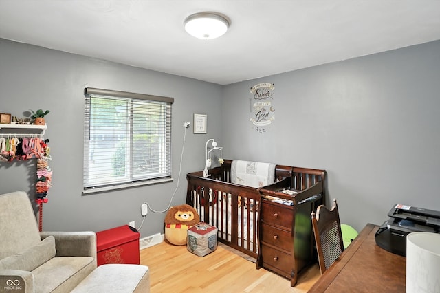 8219 Bishops Ln, Indianapolis, IN 46217 - bedroom featuring wood finished floors and a crib