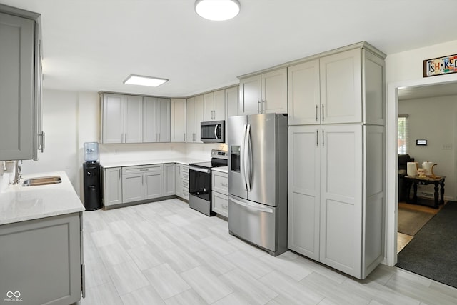 8219 Bishops Ln, Indianapolis, IN 46217 - kitchen featuring appliances with stainless steel finishes, gray cabinetry, and light stone countertops