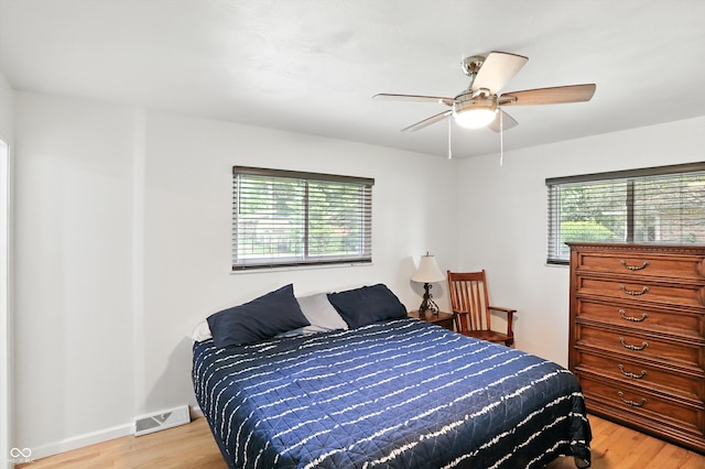 8219 Bishops Ln, Indianapolis, IN 46217 - bedroom featuring multiple windows, light wood finished floors, and ceiling fan