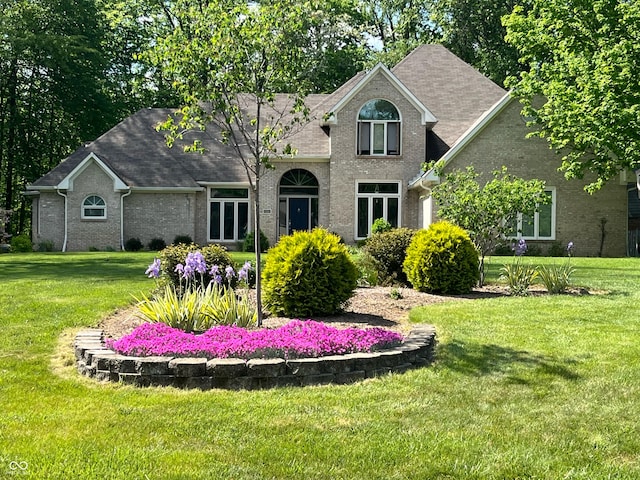 3948 S Woodfield Dr, New Palestine, IN 46163 - traditional home featuring a front yard, roof with shingles, and brick siding