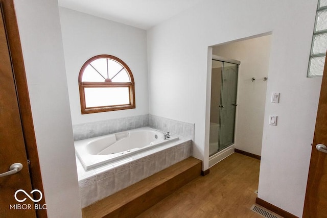 3948 S Woodfield Dr, New Palestine, IN 46163 - full bathroom featuring wood finished floors, a shower stall, and a jetted tub