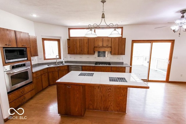 3948 S Woodfield Dr, New Palestine, IN 46163 - kitchen featuring appliances with stainless steel finishes, brown cabinets, a kitchen island, light wood-style floors, and recessed lighting