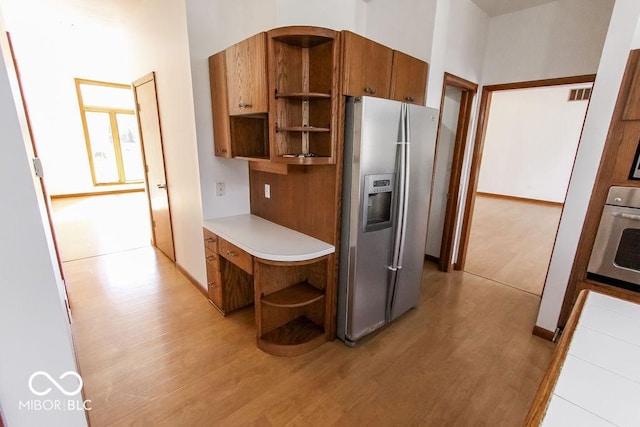 3948 S Woodfield Dr, New Palestine, IN 46163 - kitchen with open shelves, stainless steel appliances, light wood finished floors, and brown cabinetry