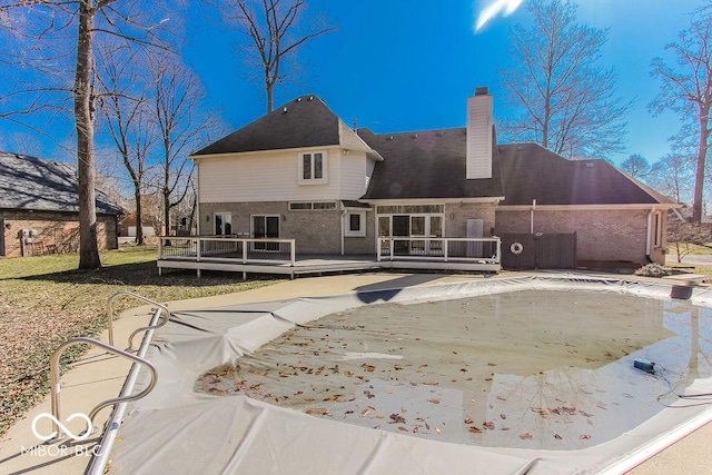 3948 S Woodfield Dr, New Palestine, IN 46163 - back of property with a deck, brick siding, a chimney, and a covered pool