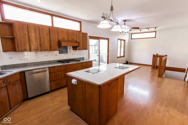 3948 S Woodfield Dr, New Palestine, IN 46163 - kitchen featuring stainless steel dishwasher, brown cabinetry, tile counters, light wood-style flooring, and tasteful backsplash