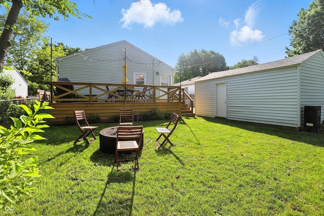 5312 Norwaldo Ave, Indianapolis, IN 46220 - view of grassy yard featuring an outdoor fire pit, a deck, and an outdoor structure