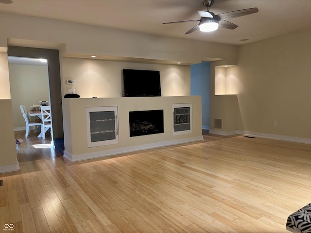 1738 E 71st St, Indianapolis, IN 46220 - unfurnished living room featuring ceiling fan, a fireplace, and wood-type flooring