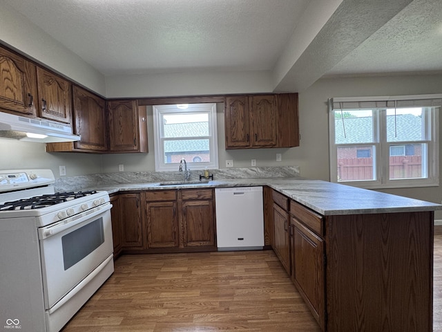 1206 Brownswood Dr, Brownsburg, IN 46112 - kitchen featuring white appliances, under cabinet range hood, a peninsula, light wood-style floors, and a textured ceiling