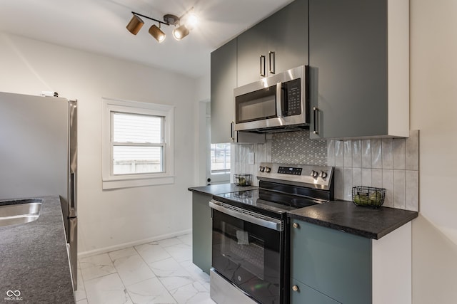 1710 N Irvington Ave, Indianapolis, IN 46218 - kitchen featuring appliances with stainless steel finishes, dark countertops, light marble finish flooring, and backsplash