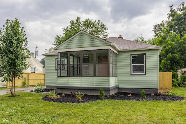 1710 N Irvington Ave, Indianapolis, IN 46218 - view of front facade featuring roof with shingles, a sunroom, and a chimney