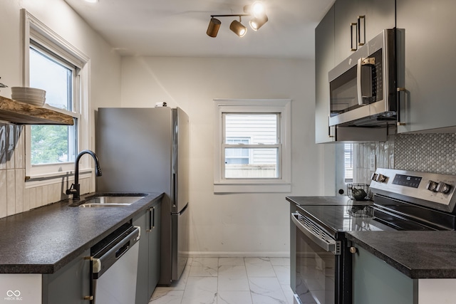 1710 N Irvington Ave, Indianapolis, IN 46218 - kitchen featuring appliances with stainless steel finishes, dark countertops, light marble finish flooring, and decorative backsplash