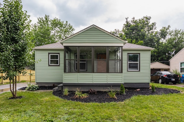 1710 N Irvington Ave, Indianapolis, IN 46218 - view of front of home featuring a front yard, roof with shingles, and a sunroom
