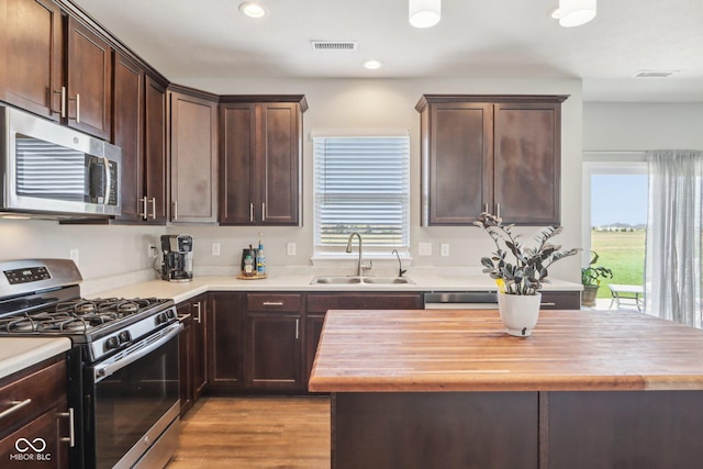 9916 Gallop Ln, Fishers, IN 46040 - kitchen featuring stainless steel appliances, wood counters, healthy amount of natural light, dark brown cabinetry, and recessed lighting