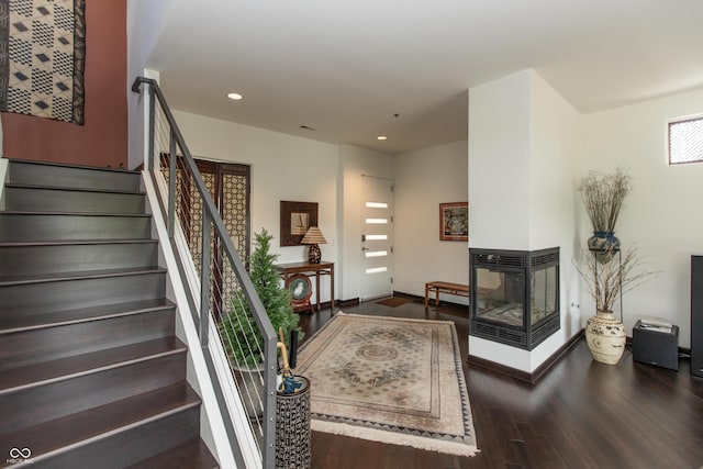 1036 Jackson St, Columbus, IN 47201 - staircase featuring wood finished floors, recessed lighting, and a multi sided fireplace