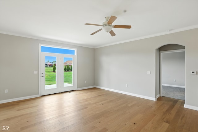 1127 Kay Dr, Greenwood, IN 46142 - empty room featuring arched walkways, crown molding, a ceiling fan, and light wood-style flooring