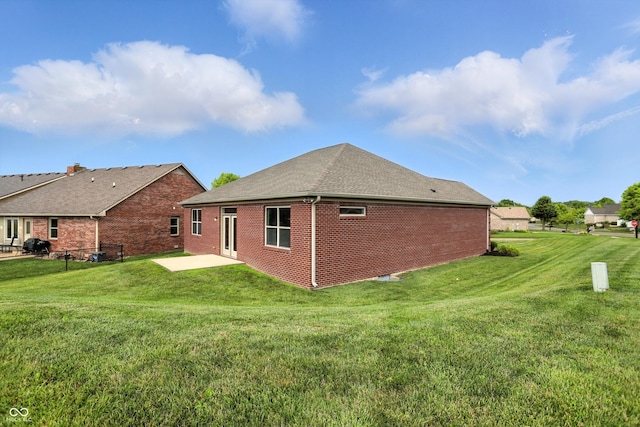 1127 Kay Dr, Greenwood, IN 46142 - rear view of house with brick siding, a patio area, a yard, and a shingled roof