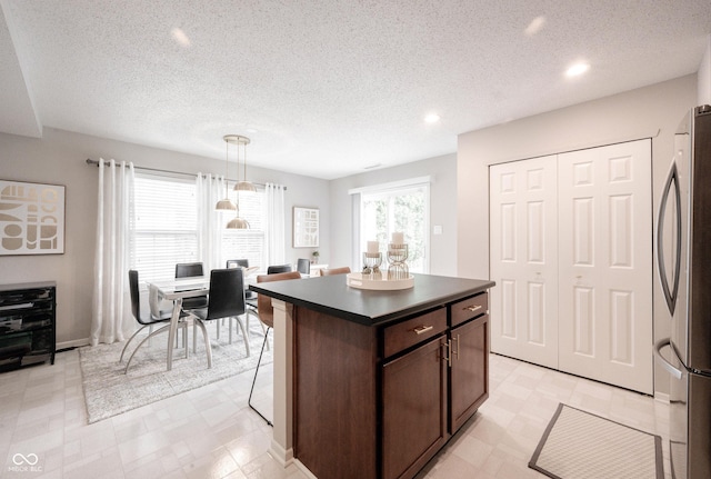 14459 Forsythia Ln, Fishers, IN 46038 - kitchen featuring dark countertops, freestanding refrigerator, light floors, dark brown cabinetry, and recessed lighting