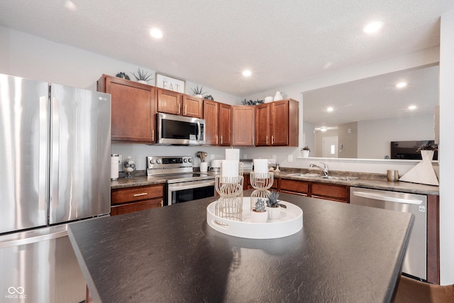 14459 Forsythia Ln, Fishers, IN 46038 - kitchen with stainless steel appliances, dark countertops, recessed lighting, brown cabinets, and a kitchen island