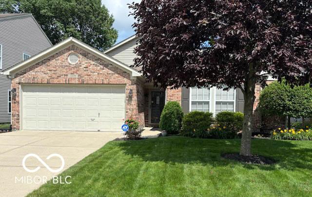 14459 Forsythia Ln, Fishers, IN 46038 - obstructed view of property with brick siding, an attached garage, concrete driveway, and a front lawn
