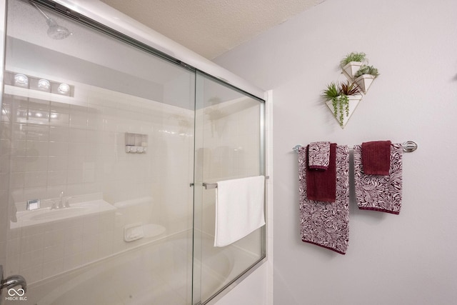 14459 Forsythia Ln, Fishers, IN 46038 - full bathroom featuring combined bath / shower with glass door and a textured ceiling