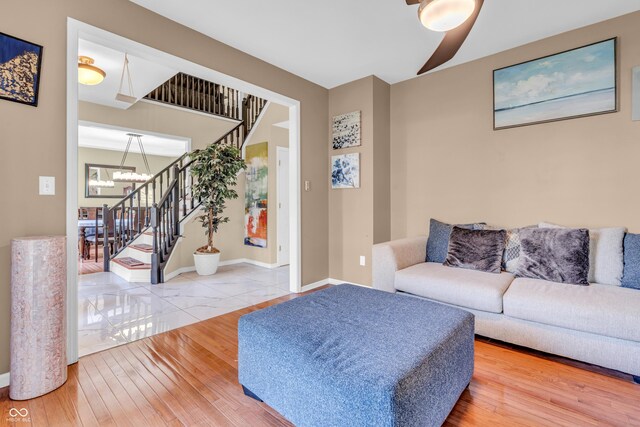 6374 Timberbluff Cir, Avon, IN 46123 - living room featuring stairs, a chandelier, ceiling fan, and wood finished floors