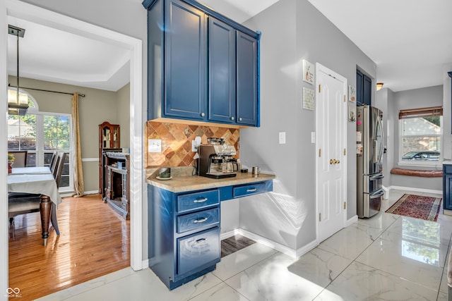 6374 Timberbluff Cir, Avon, IN 46123 - kitchen with blue cabinetry, freestanding refrigerator, decorative backsplash, light countertops, and hanging light fixtures