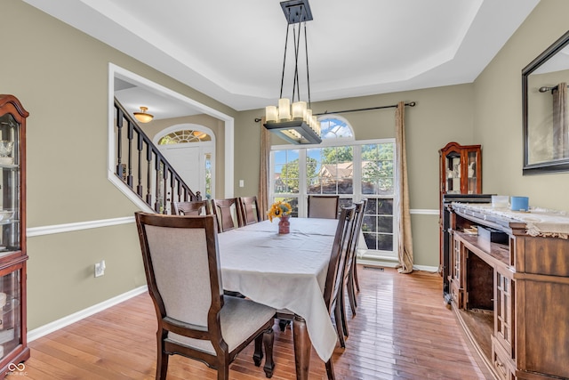 6374 Timberbluff Cir, Avon, IN 46123 - dining space featuring a raised ceiling, wood-type flooring, stairs, and a chandelier