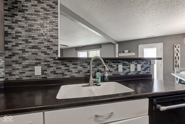 9593 W Constellation Dr, Pendleton, IN 46064 - kitchen featuring a textured ceiling, dishwasher, backsplash, dark countertops, and white cabinetry