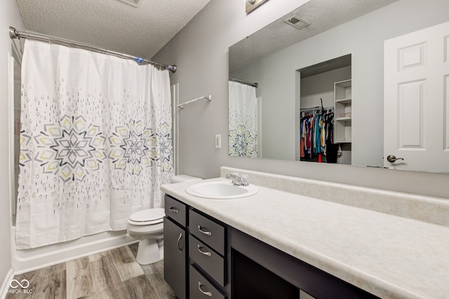 9593 W Constellation Dr, Pendleton, IN 46064 - bathroom featuring wood finished floors, vanity, shower / bath combo with shower curtain, and a textured ceiling