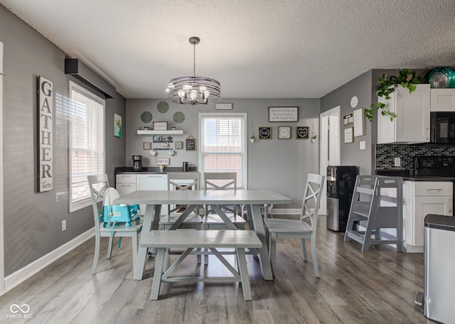 9593 W Constellation Dr, Pendleton, IN 46064 - dining space featuring a textured ceiling, a chandelier, and light wood-style flooring