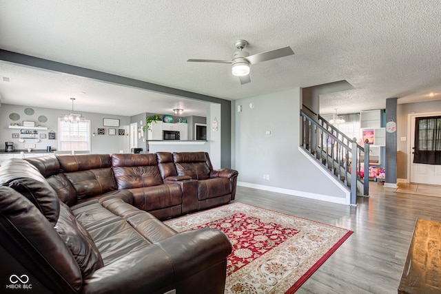 9593 W Constellation Dr, Pendleton, IN 46064 - living room featuring a chandelier, stairway, a textured ceiling, wood finished floors, and a ceiling fan