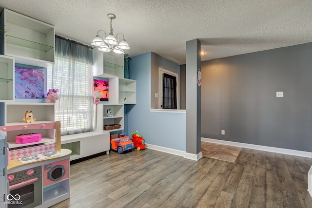 9593 W Constellation Dr, Pendleton, IN 46064 - rec room with a chandelier, wood finished floors, and a textured ceiling