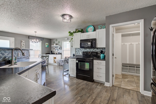 9593 W Constellation Dr, Pendleton, IN 46064 - kitchen with black appliances, backsplash, a chandelier, white cabinetry, and a textured ceiling