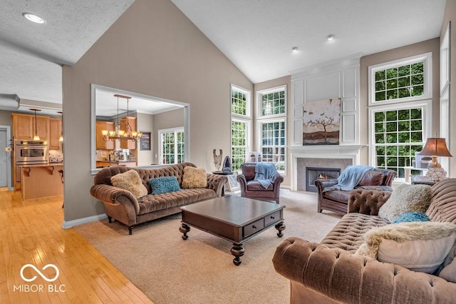 5865 Osage Dr, Carmel, IN 46033 - living area featuring high vaulted ceiling, a chandelier, a fireplace, light wood-type flooring, and recessed lighting
