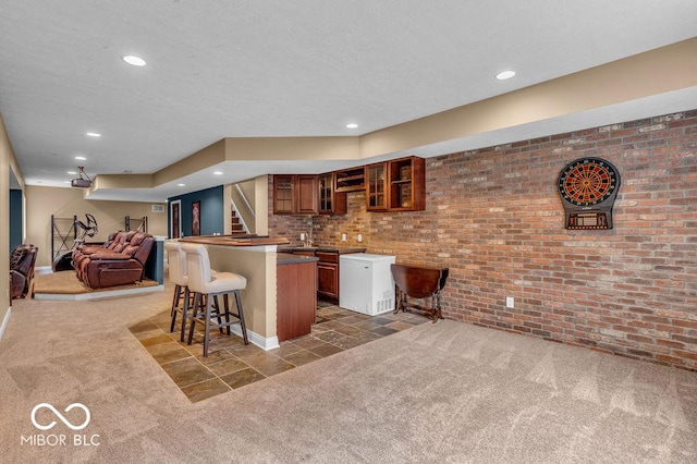 5865 Osage Dr, Carmel, IN 46033 - kitchen with carpet flooring, a kitchen breakfast bar, brown cabinetry, glass insert cabinets, and recessed lighting