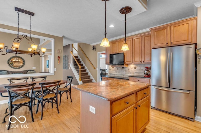 5865 Osage Dr, Carmel, IN 46033 - kitchen featuring freestanding refrigerator, ornamental molding, light wood-style floors, backsplash, and a kitchen island